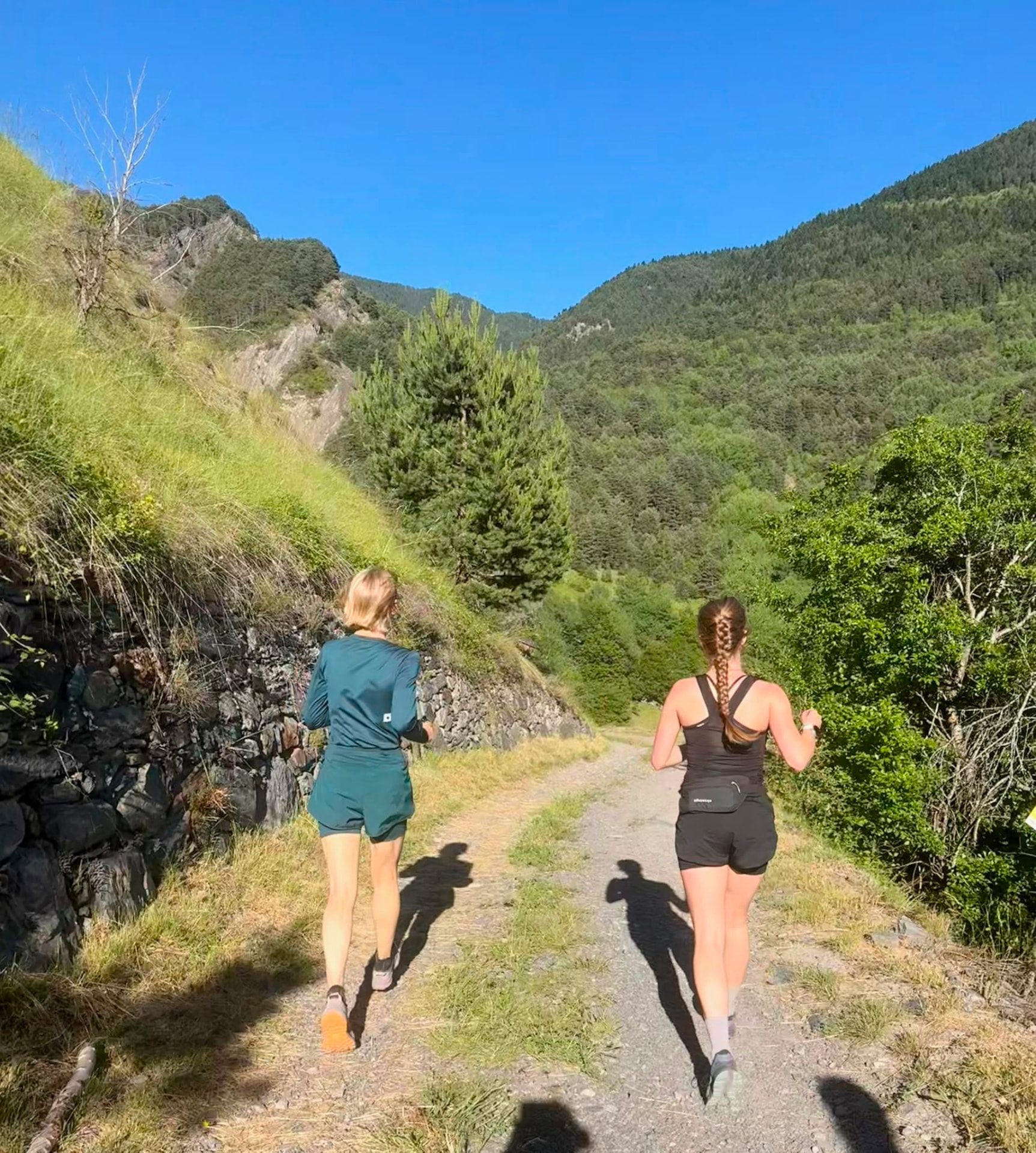 Two runners moving along a Pyrenean trail